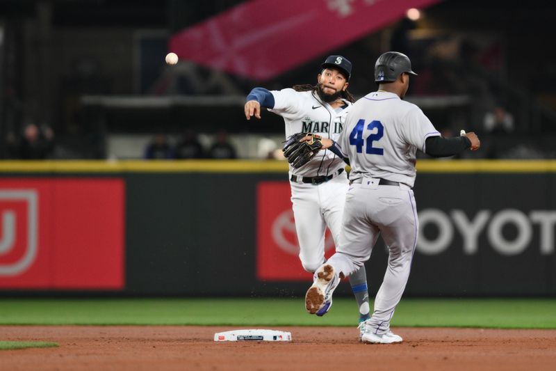 Apr 15, 2023; Seattle, Washington, USA; Seattle Mariners shortstop J.P. Crawford turns the double play with Colorado Rockies third baseman Elehuris Montero out at second base during the second inning at T-Mobile Park. Mandatory Credit: Steven Bisig-USA TODAY Sports