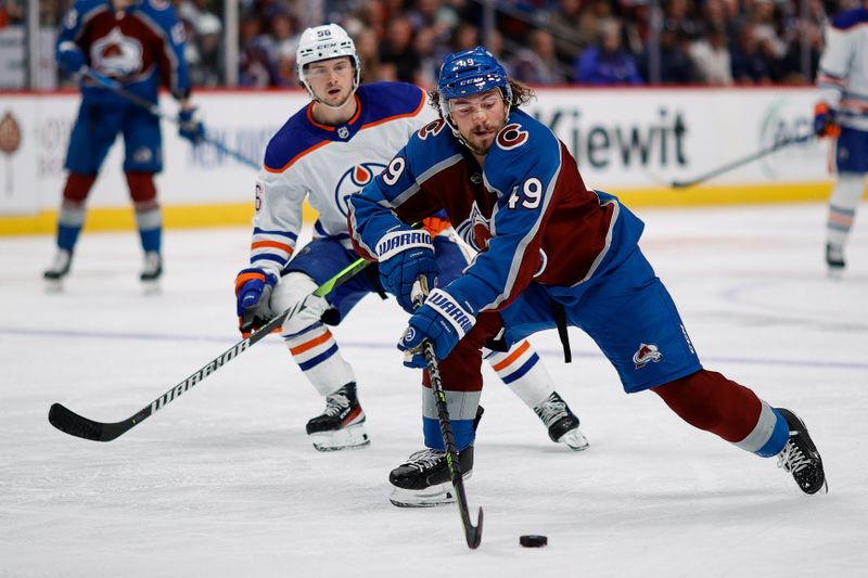 Apr 11, 2023; Denver, Colorado, USA; Colorado Avalanche defenseman Samuel Girard (49) controls the puck ahead of Edmonton Oilers right wing Kailer Yamamoto (56) in the third period at Ball Arena. Mandatory Credit: Isaiah J. Downing-USA TODAY Sports