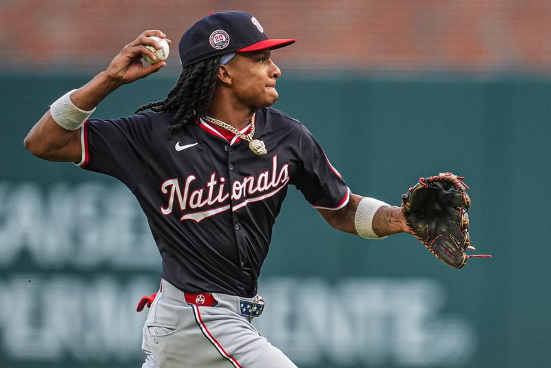 May 13, 2025; Cumberland, Georgia, USA; Washington Nationals shortstop CJ Abrams (5) fields and throws for an error on a ground ball hit by Atlanta Braves third baseman Austin Riley (27) (not pictured) during the first inning at Truist Park. Mandatory Credit: Dale Zanine-Imagn Images