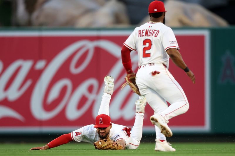 May 23, 2025; Anaheim, California, USA;  Los Angeles Angels center fielder Matthew Lugo (15) dives for a ball hit for a single by Miami Marlins catcher Nick Fortes (4, not pictured) as second baseman Luis Rengifo (2) watches during the fourth inning at Angel Stadium. Mandatory Credit: Kiyoshi Mio-Imagn Images