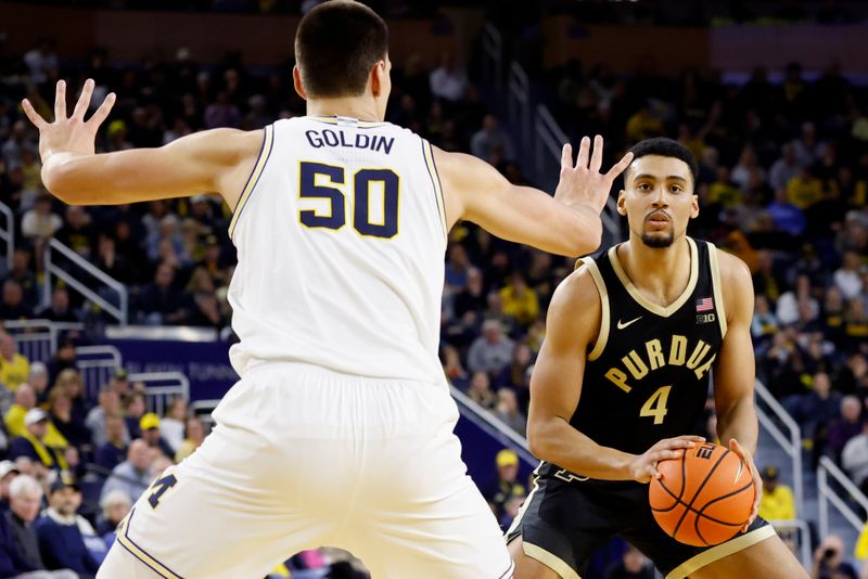 Feb 11, 2025; Ann Arbor, Michigan, USA;  Purdue Boilermakers forward Trey Kaufman-Renn (4) is defended by Michigan Wolverines center Vladislav Goldin (50) in the second half at Crisler Center. Mandatory Credit: Rick Osentoski-Imagn Images