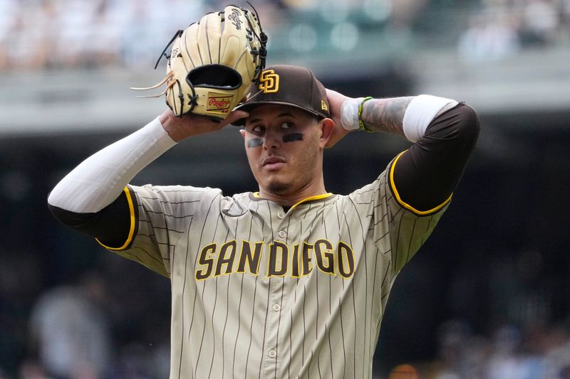 Jun 7, 2025; Milwaukee, Wisconsin, USA; San Diego Padres third base Manny Machado (13) puts his hat on as he take the field after getting called out at first base against the Milwaukee Brewers in the third inning at American Family Field. Mandatory Credit: Michael McLoone-Imagn Images