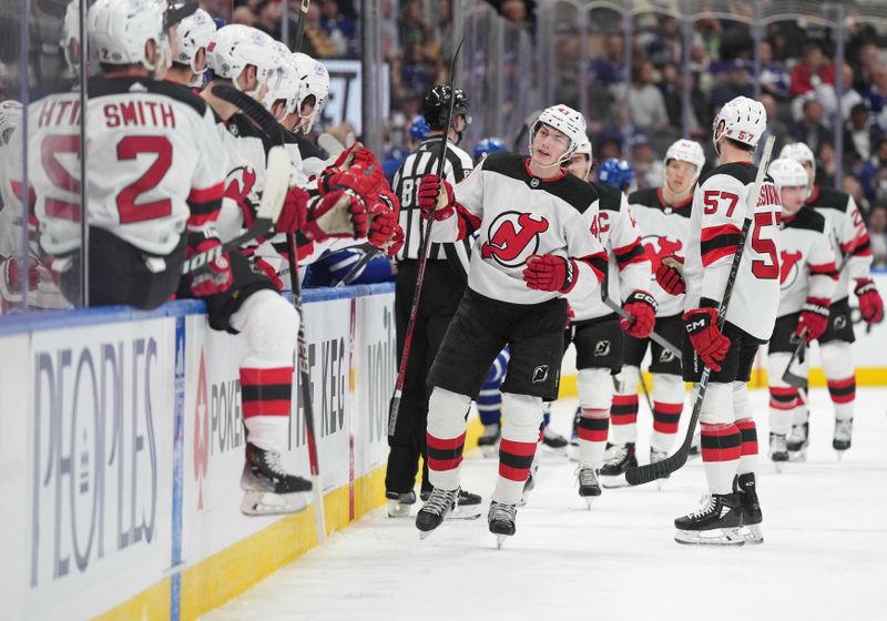 Mar 26, 2024; Toronto, Ontario, CAN; New Jersey Devils defenseman Luke Hughes (43) celebrates at the bench after scoring a goal against the Toronto Maple Leafs during the first period at Scotiabank Arena. Mandatory Credit: Nick Turchiaro-USA TODAY Sports