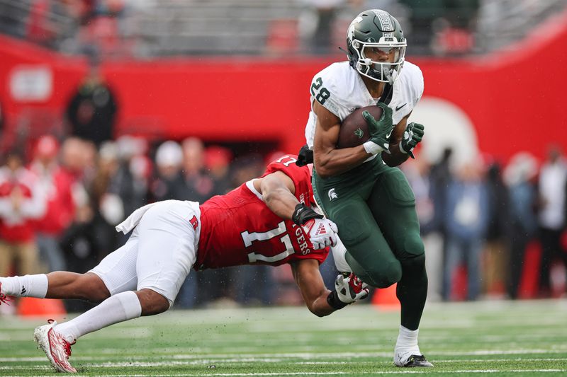 Oct 14, 2023; Piscataway, New Jersey, USA; Michigan State Spartans defensive back Philipp Davis (28) is tackled by Rutgers Scarlet Knights linebacker Deion Jennings (17)  during the first half at SHI Stadium. Mandatory Credit: Vincent Carchietta-USA TODAY Sports