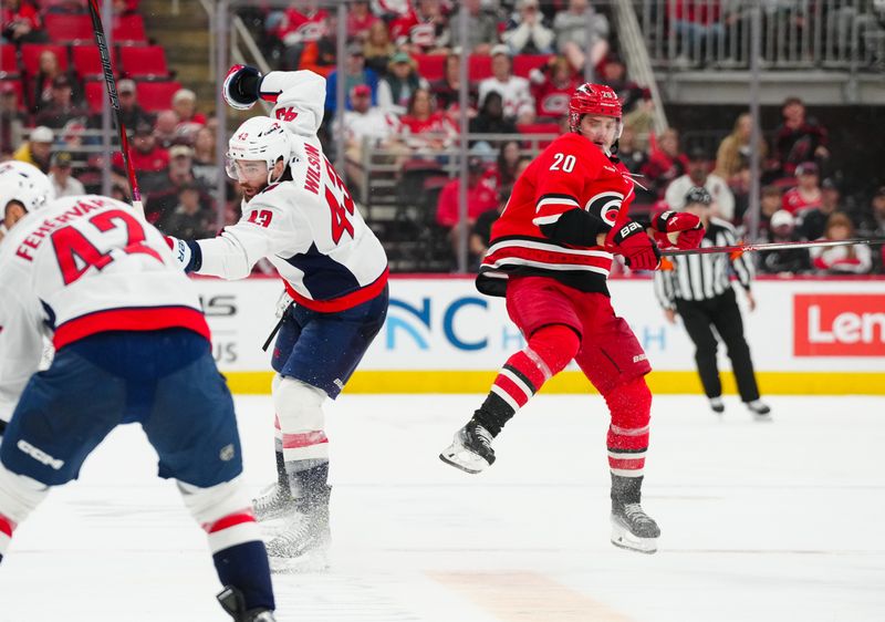 Apr 2, 2025; Raleigh, North Carolina, USA;  Carolina Hurricanes center Sebastian Aho (20) side steps a check by Washington Capitals right wing Tom Wilson (43) during the third period at Lenovo Center. Mandatory Credit: James Guillory-Imagn Images