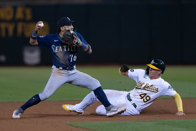 Sep 18, 2023; Oakland, California, USA;  Oakland Athletics first baseman Ryan Noda (49) slides during the eighth inning against Seattle Mariners second baseman Jose Caballero (76) at Oakland-Alameda County Coliseum. Mandatory Credit: Stan Szeto-USA TODAY Sports