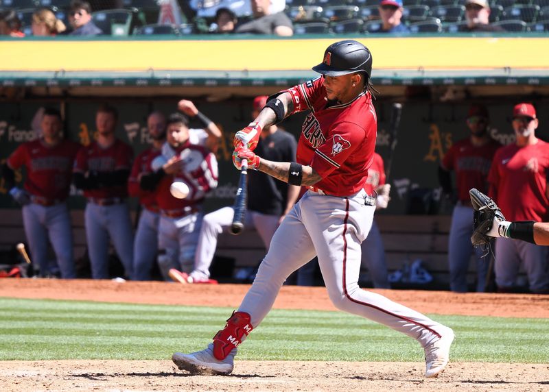 May 17, 2023; Oakland, California, USA; Arizona Diamondbacks infielder Ketel Marte (4) hits an RBI single against the Oakland Athletics during the ninth inning at Oakland-Alameda County Coliseum. Mandatory Credit: Kelley L Cox-USA TODAY Sports