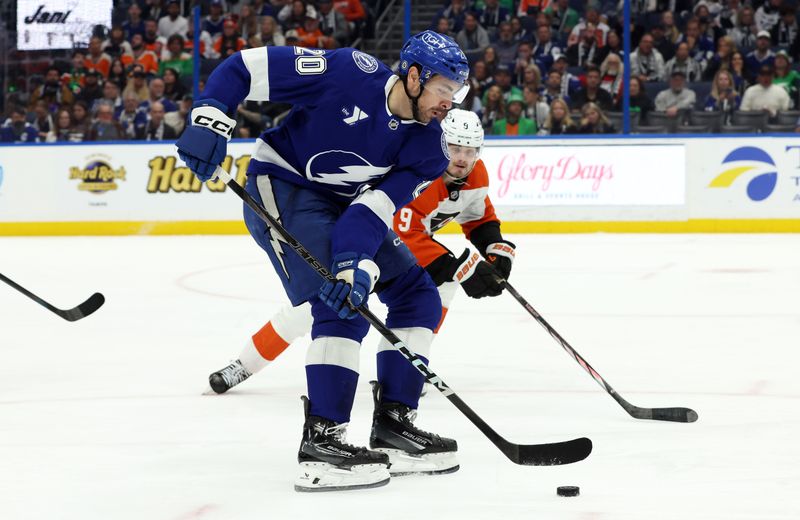 Mar 17, 2025; Tampa, Florida, USA;  Tampa Bay Lightning left wing Nick Paul (20) skates with the puck as Philadelphia Flyers defenseman Jamie Drysdale (9) defends during the third period at Amalie Arena. Mandatory Credit: Kim Klement Neitzel-Imagn Images