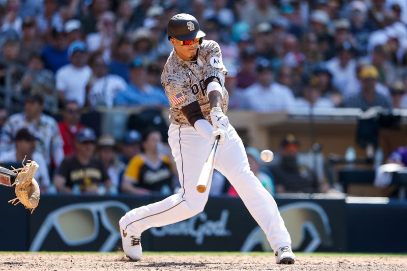 Aug 4, 2024; San Diego, California, USA; San Diego Padres third basemen Manny Machado (13) hits an rbi single during the eighth inning against the Colorado Rockies at Petco Park. Mandatory Credit: David Frerker-USA TODAY Sports