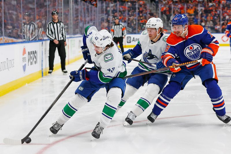 Apr 13, 2024; Edmonton, Alberta, CAN; Vancouver Canucks defensemen Quinn Hughes (43) protects the puck from Edmonton Oilers forward Evander Kane (91) during the third period at Rogers Place. Mandatory Credit: Perry Nelson-USA TODAY Sports