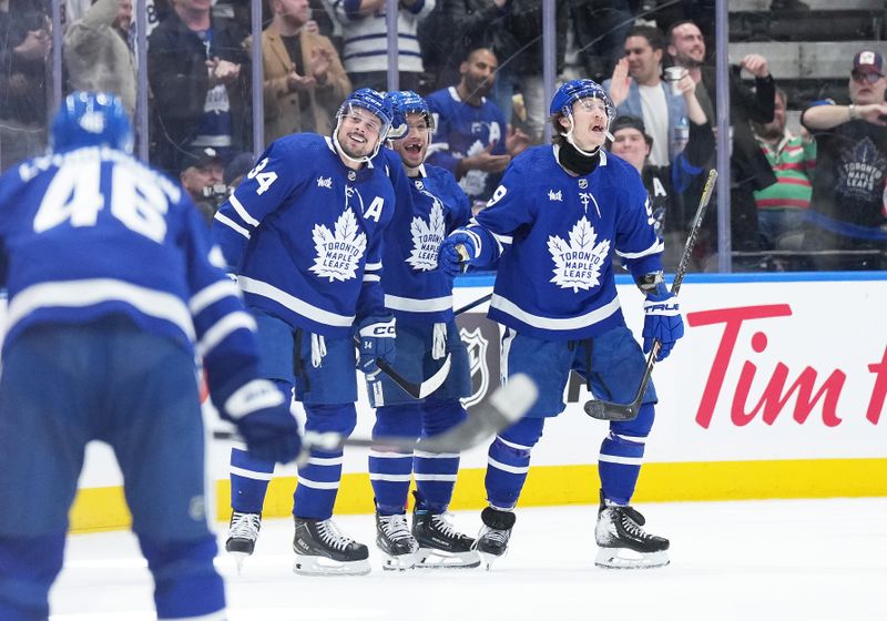 Mar 26, 2024; Toronto, Ontario, CAN; Toronto Maple Leafs center Auston Matthews (34) scores a goal and celebrates with center Max Domi (11) and left wing Tyler Bertuzzi (59) against the New Jersey Devils during the second period at Scotiabank Arena. Mandatory Credit: Nick Turchiaro-USA TODAY Sports