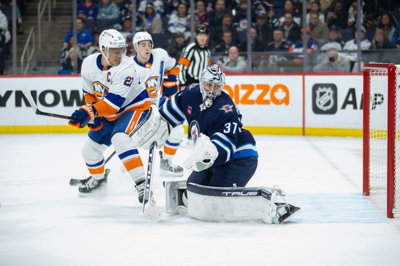 Jan 16, 2024; Winnipeg, Manitoba, CAN; New York Islanders forward Anders Lee (27) scores on Winnipeg Jets goalie Connor Hellebuyck (37) during the first period at Canada Life Centre. Mandatory Credit: Terrence Lee-USA TODAY Sports