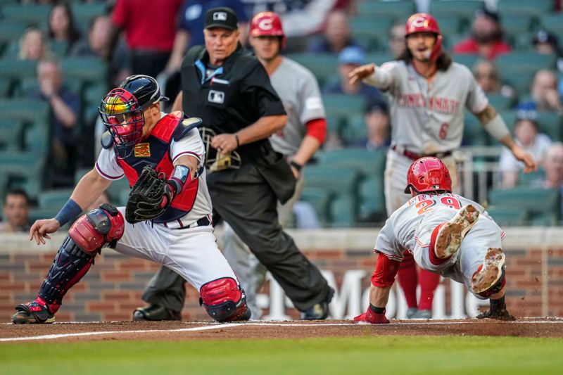 Apr 12, 2023; Cumberland, Georgia, USA; Cincinnati Reds center fielder TJ Friedl (29) dives into home plate behind Atlanta Braves catcher Sean Murphy (12) to score a run during the first inning at Truist Park. Mandatory Credit: Dale Zanine-USA TODAY Sports