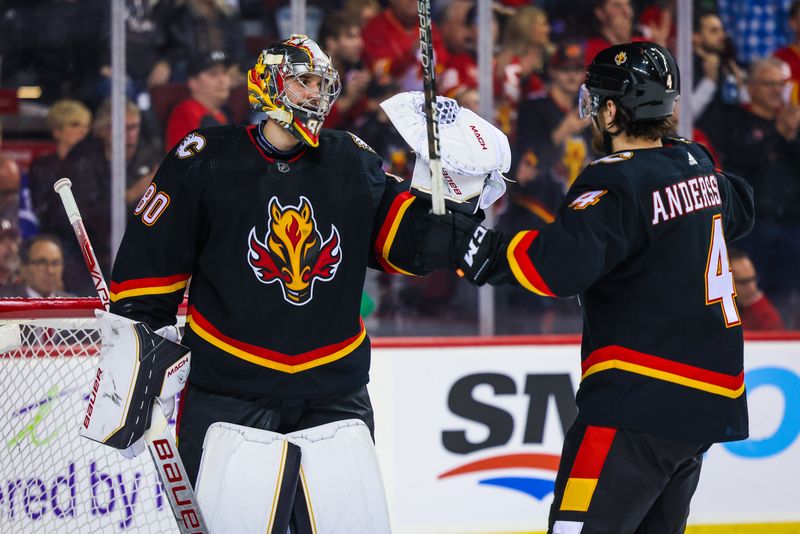 Jan 21, 2023; Calgary, Alberta, CAN; Calgary Flames goaltender Dan Vladar (80) and defenseman Rasmus Andersson (4) celebrates win over the Tampa Bay Lightning at Scotiabank Saddledome. Mandatory Credit: Sergei Belski-USA TODAY Sports