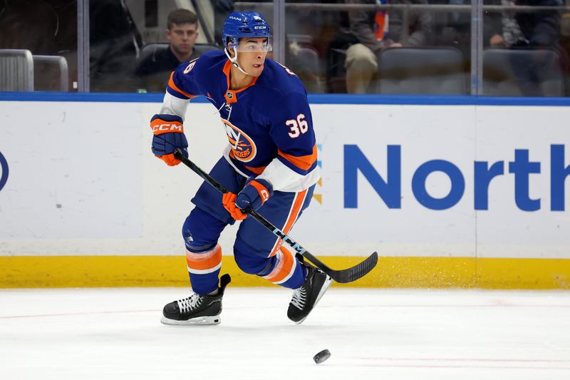 Nov 30, 2024; Elmont, New York, USA; New York Islanders defenseman Isaiah George (36) plays the puck against the Buffalo Sabres during the first period at UBS Arena. Mandatory Credit: Brad Penner-Imagn Images