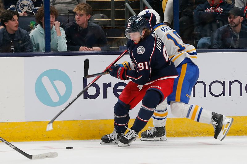 Feb 23, 2024; Columbus, Ohio, USA; Columbus Blue Jackets left wing Kent Johnson (91) avoids the check of Buffalo Sabres center Peyton Krebs (19) during the third period at Nationwide Arena. Mandatory Credit: Russell LaBounty-USA TODAY Sports