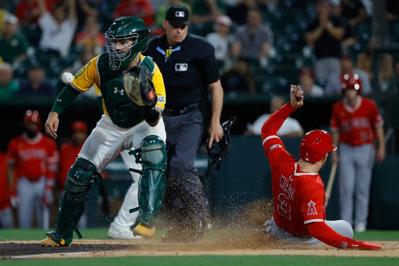 May 20, 2025; West Sacramento, California, USA; Los Angeles Angels left fielder Taylor Ward (3) avoids the tag by Athletics catcher Shea Langeliers (23) to score a run during the fifth inning against the Athletics at Sutter Health Park. Mandatory Credit: Sergio Estrada-Imagn Images