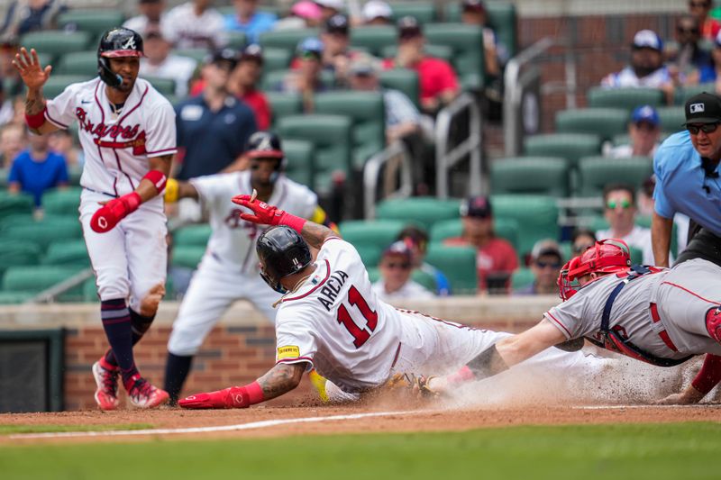 Aug 2, 2023; Cumberland, Georgia, USA; Atlanta Braves shortstop Orlando Arcia (11) slides into home plate to score a run past Los Angeles Angels catcher Chad Wallach (35) during the fourth inning at Truist Park. Mandatory Credit: Dale Zanine-USA TODAY Sports