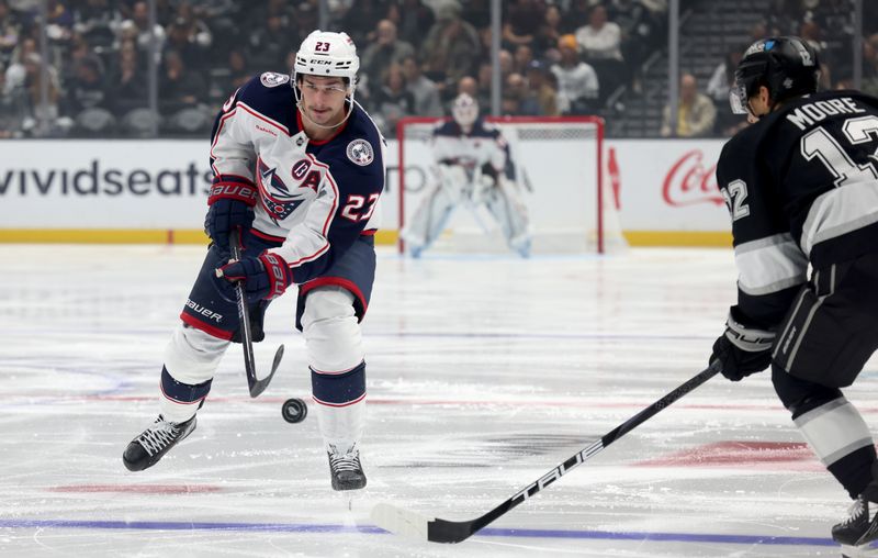 Nov 9, 2024; Los Angeles, California, USA; Columbus Blue Jackets center Sean Monahan (23) passes against Los Angeles Kings left wing Trevor Moore (12) during the third period at Crypto.com Arena. Mandatory Credit: Jason Parkhurst-Imagn Images