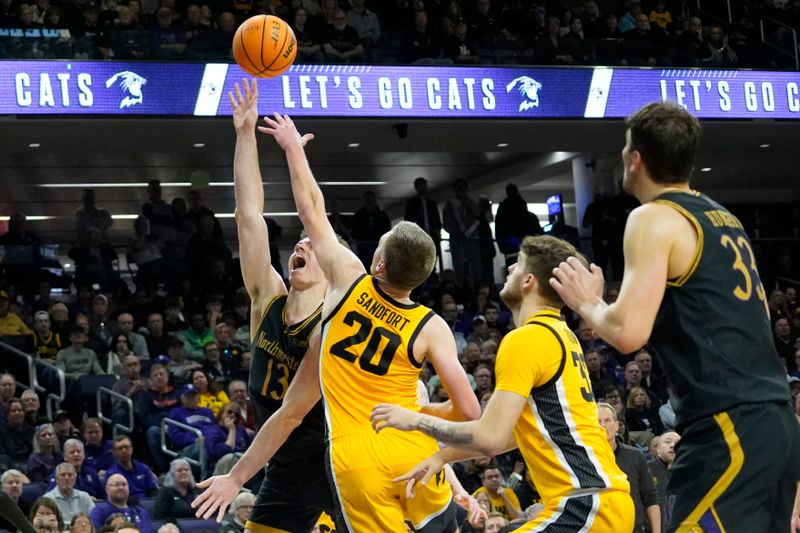 Mar 2, 2024; Evanston, Illinois, USA; Iowa Hawkeyes forward Payton Sandfort (20) defends Northwestern Wildcats guard Brooks Barnhizer (13) during the second half at Welsh-Ryan Arena. Mandatory Credit: David Banks-USA TODAY Sports