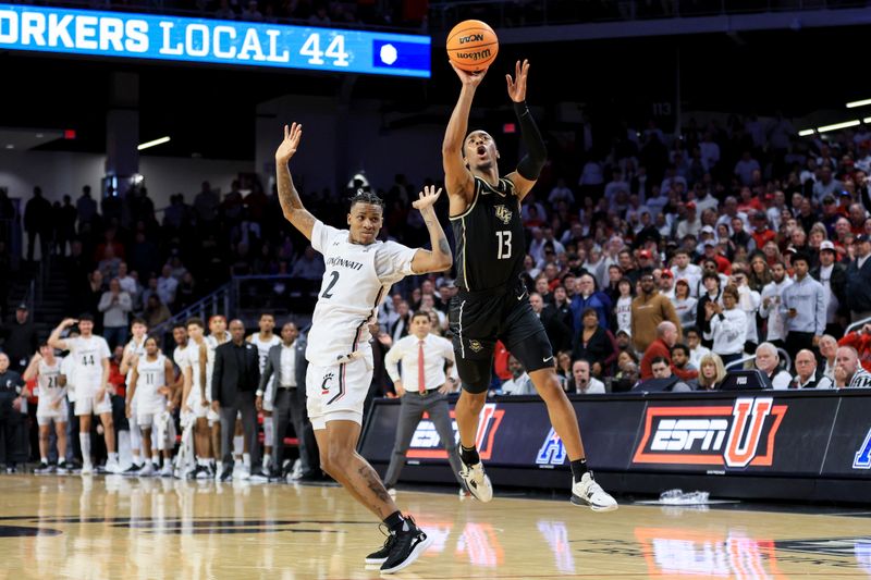 Feb 4, 2023; Cincinnati, Ohio, USA;  UCF Knights guard C.J. Kelly (13) reacts as he is fouled by Cincinnati Bearcats guard Landers Nolley II (2) as he attempts a three-point basket in the second half at Fifth Third Arena. Mandatory Credit: Aaron Doster-USA TODAY Sports