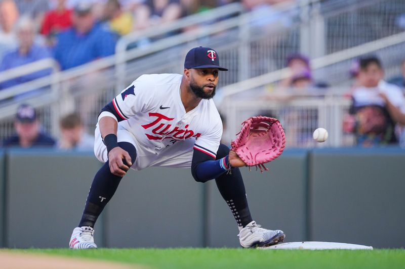 Jun 13, 2024; Minneapolis, Minnesota, USA; Minnesota Twins first base Carlos Santana (30) `catches the ball for the out against the Oakland Athletics in the first inning at Target Field. Mandatory Credit: Brad Rempel-USA TODAY Sports