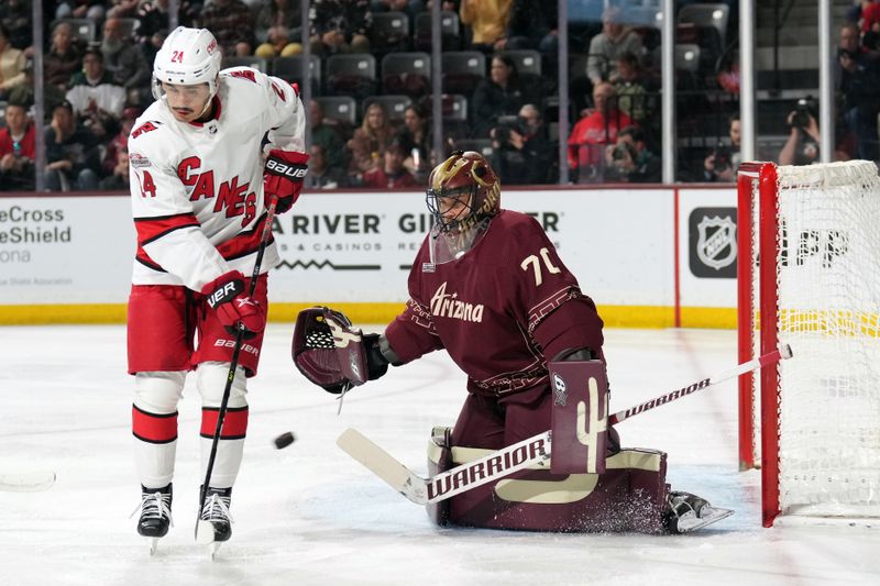 Mar 3, 2023; Tempe, Arizona, USA; Arizona Coyotes goaltender Karel Vejmelka (70) makes a save in front of Carolina Hurricanes center Seth Jarvis (24) during the first period at Mullett Arena. Mandatory Credit: Joe Camporeale-USA TODAY Sports