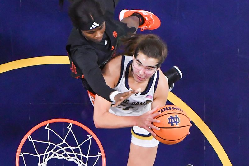 Jan 14, 2024; South Bend, Indiana, USA; Notre Dame Fighting Irish forward Maddy Westbeld (21) goes up for a shot as Miami Hurricanes guard Lemyah Hylton (1) defends in the first half at the Purcell Pavilion. Mandatory Credit: Matt Cashore-USA TODAY Sports