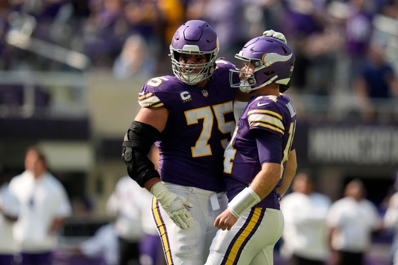 Minnesota Vikings quarterback Sam Darnold (14) celebrates with teammate offensive tackle Brian O'Neill (75) after throwing a touchdown pass during the second half of an NFL football game against the Houston Texans, Sunday, Sept. 22, 2024, in Minneapolis. (AP Photo/Abbie Parr)