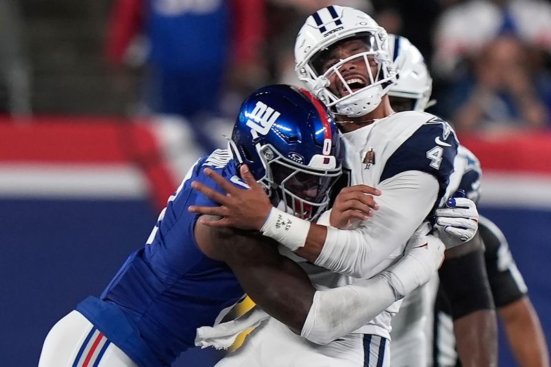 New York Giants linebacker Brian Burns (0) hits Dallas Cowboys quarterback Dak Prescott (4) during the first quarter of an NFL football game, Thursday, Sept. 26, 2024, in East Rutherford, N.J. (AP Photo/Bryan Woolston)