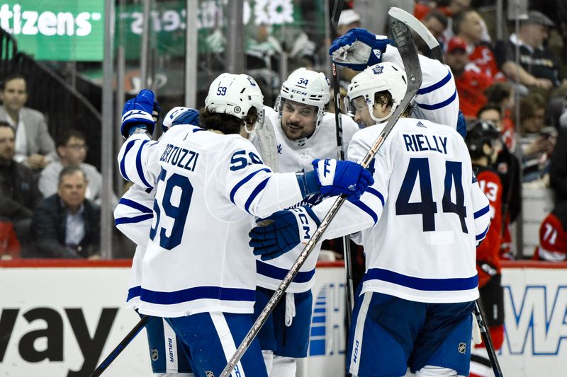 Apr 9, 2024; Newark, New Jersey, USA; Toronto Maple Leafs center Auston Matthews (34) celebrates with teammates after scoring a goal against the New Jersey Devils during the third period at Prudential Center. Mandatory Credit: John Jones-USA TODAY Sports