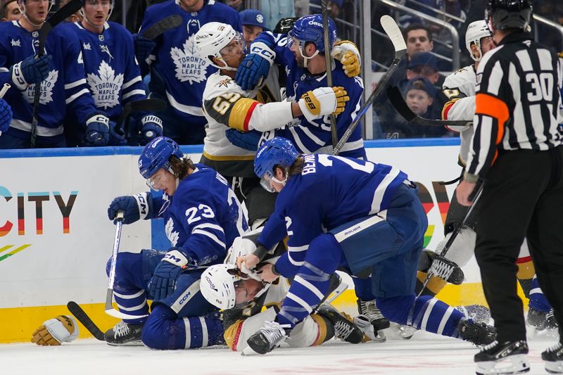 Nov 20, 2024; Toronto, Ontario, CAN; Toronto Maple Leafs defenseman Simon Benoit (2) fights with Vegas Golden Knights defenseman Zach Whitecloud (2) and forward Keegan Kolesar (55) fights with Toronto Maple Leafs defenseman Conor Timmins (25) after a hit on forward Matthew Knies (23) at Scotiabank Arena. Mandatory Credit: John E. Sokolowski-Imagn Images