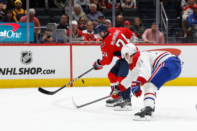 Oct 31, 2024; Washington, District of Columbia, USA; Washington Capitals center Connor McMichael (24) attempts to control the puck as Montreal Canadiens defenseman Kaiden Guhle (21) defends in the first period at Capital One Arena. Mandatory Credit: Geoff Burke-Imagn Images