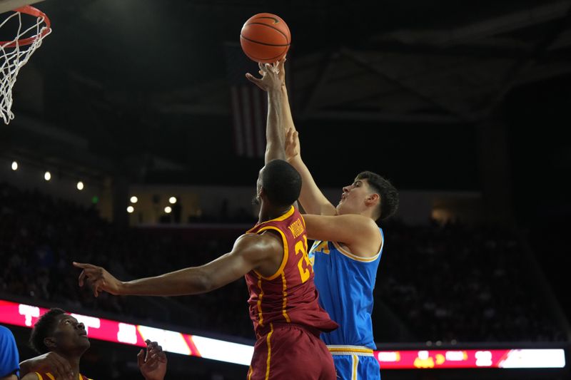 Jan 27, 2024; Los Angeles, California, USA; UCLA Bruins center Aday Mara (15) shoots the ball against Southern California Trojans forward Joshua Morgan (24)  in the first half at Galen Center. Mandatory Credit: Kirby Lee-USA TODAY Sports