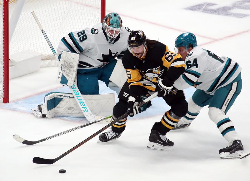 Nov 16, 2024; Pittsburgh, Pennsylvania, USA;  San Jose Sharks goaltender Mackenzie Blackwood (29) and center Mikael Granlund (64) defend Pittsburgh Penguins defenseman Erik Karlsson (65) in overtime at PPG Paints Arena. Mandatory Credit: Charles LeClaire-Imagn Images