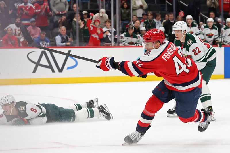 Oct 17, 2025; Washington, District of Columbia, USA; Washington Capitals defenseman Martin Fehérváry (42) shoots the puck as Minnesota Wild defenseman Zeev Buium (8) defends during the third period at Capital One Arena. Mandatory Credit: Geoff Burke-Imagn Images