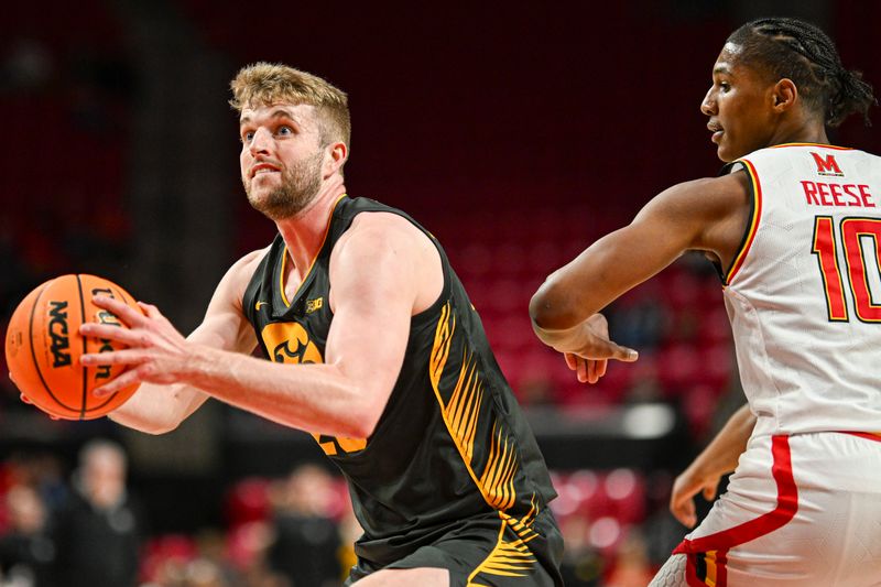 Feb 14, 2024; College Park, Maryland, USA;  Iowa Hawkeyes forward Ben Krikke (23) makes a move past Maryland Terrapins forward Julian Reese (10) during the first half at Xfinity Center. Mandatory Credit: Tommy Gilligan-USA TODAY Sports