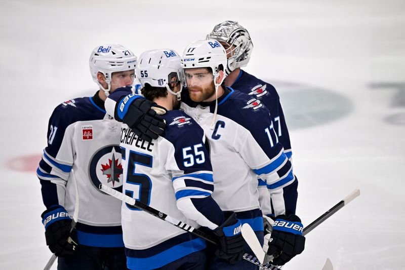 May 17, 2025; Dallas, Texas, USA; Winnipeg Jets center Adam Lowry (17) hugs center Mark Scheifele (55) after the Jets lose to the Dallas Stars during the overtime period in game six of the second round of the 2025 Stanley Cup Playoffs at American Airlines Center. Mandatory Credit: Jerome Miron-Imagn Images