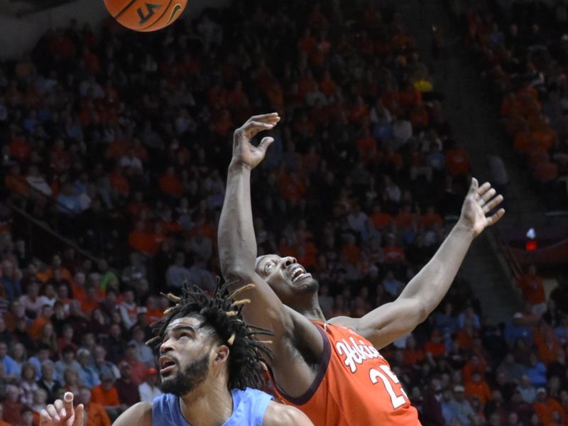 Dec 4, 2022; Blacksburg, Virginia, USA; Virginia Tech Hokies forward Justyn Mutts (25) and North Carolina Tar Heels guard R.J. Davis (4) battle for rebound in the second half at Cassell Coliseum. Mandatory Credit: Lee Luther Jr.-USA TODAY Sports