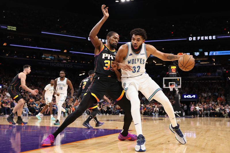 PHOENIX, ARIZONA - NOVEMBER 15: Karl-Anthony Towns #32 of the Minnesota Timberwolves handles the ball against Kevin Durant #35 of the Phoenix Suns during the first half of the NBA game at Footprint Center on November 15, 2023 in Phoenix, Arizona. NOTE TO USER: User expressly acknowledges and agrees that, by downloading and or using this photograph, User is consenting to the terms and conditions of the Getty Images License Agreement.  (Photo by Christian Petersen/Getty Images)