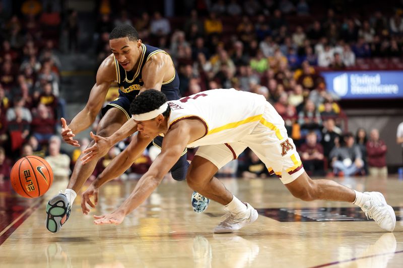 Jan 16, 2025; Minneapolis, Minnesota, USA; Michigan Wolverines guard Nimari Burnett (4) and Minnesota Golden Gophers guard Isaac Asuma (1) dive for the ball during the second half at Williams Arena. Mandatory Credit: Matt Krohn-Imagn Images