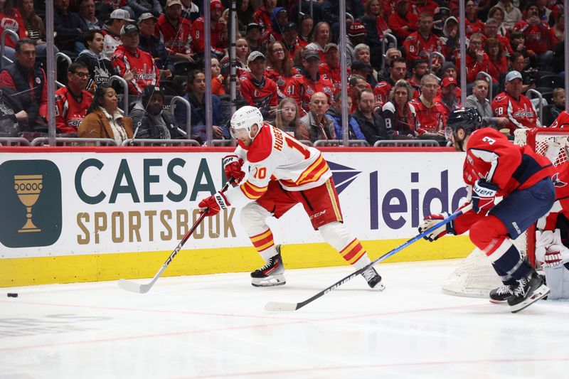 Feb 25, 2025; Washington, District of Columbia, USA; Calgary Flames left wing Jonathan Huberdeau (10) and Washington Capitals defenseman Matt Roy (3) chase the puck in the second period at Capital One Arena. Mandatory Credit: Geoff Burke-Imagn Images
