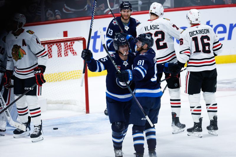 Oct 11, 2024; Winnipeg, Manitoba, CAN; Winnipeg Jets forward Mark Scheifele (55) is congratulated by Winnipeg Jets forward Kyle Connor (81) on his goal against the Chicago Blackhawks during the third period at Canada Life Centre. Mandatory Credit: Terrence Lee-Imagn Images