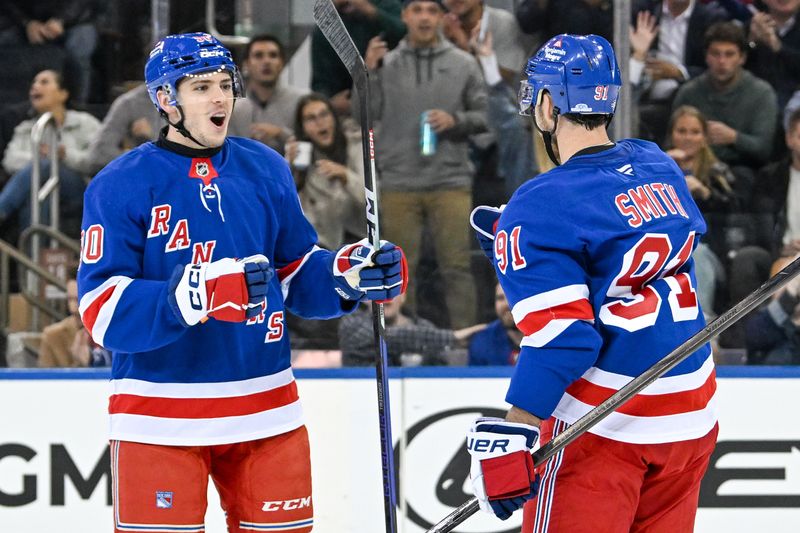 Oct 14, 2024; New York, New York, USA;  New York Rangers defenseman Victor Mancini (90) celebrates the goal by New York Rangers right wing Reilly Smith (91) against the Detroit Red Wings during the third period at Madison Square Garden. Mandatory Credit: Dennis Schneidler-Imagn Images