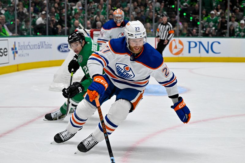 May 23, 2024; Dallas, Texas, USA; Edmonton Oilers defenseman Brett Kulak (27) keeps the puck away from Dallas Stars left wing Jason Robertson (21) during the second period in game one of the Western Conference Final of the 2024 Stanley Cup Playoffs at American Airlines Center. Mandatory Credit: Jerome Miron-USA TODAY Sports