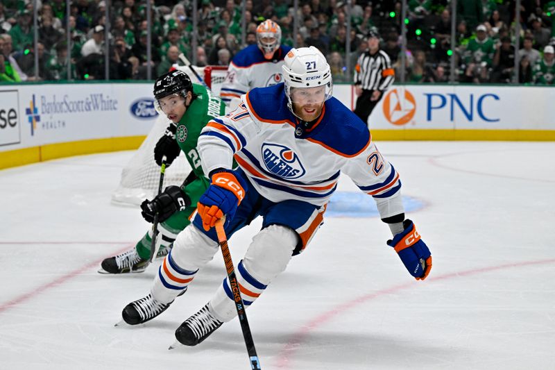 May 23, 2024; Dallas, Texas, USA; Edmonton Oilers defenseman Brett Kulak (27) keeps the puck away from Dallas Stars left wing Jason Robertson (21) during the second period in game one of the Western Conference Final of the 2024 Stanley Cup Playoffs at American Airlines Center. Mandatory Credit: Jerome Miron-USA TODAY Sports