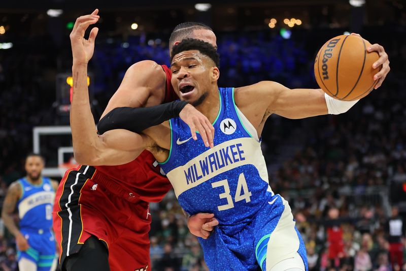 MILWAUKEE, WISCONSIN - FEBRUARY 13: Giannis Antetokounmpo #34 of the Milwaukee Bucks is fouled by Caleb Martin #16 of the Miami Heat during the first half of a game at Fiserv Forum on February 13, 2024 in Milwaukee, Wisconsin. NOTE TO USER: User expressly acknowledges and agrees that, by downloading and or using this photograph, User is consenting to the terms and conditions of the Getty Images License Agreement. (Photo by Stacy Revere/Getty Images)