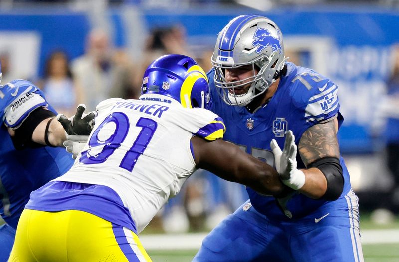 Detroit Lions guard Jonah Jackson (73) blocks against Los Angeles Rams defensive tackle Kobie Turner (91) during the first half of an NFL wild-card playoff football game Sunday, Jan. 14, 2024 in Detroit. (AP Photo/Duane Burleson)