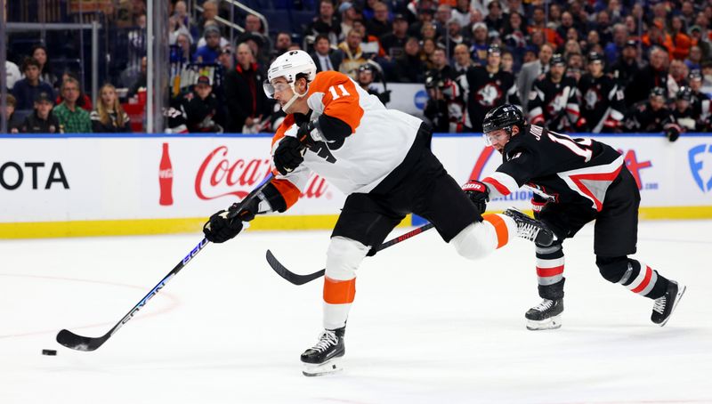 Nov 3, 2023; Buffalo, New York, USA;  Buffalo Sabres defenseman Henri Jokiharju (10) tries to defends as Philadelphia Flyers right wing Travis Konecny (11) takes a shot on goal and scores during the first period at KeyBank Center. Mandatory Credit: Timothy T. Ludwig-USA TODAY Sports