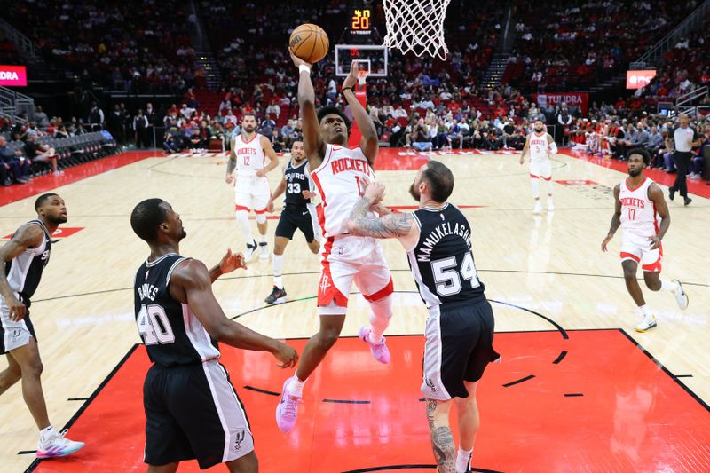 HOUSTON, TEXAS - OCTOBER 17: Amen Thompson #1 of the Houston Rockets shoots over Sandro Mamukelashvili #54 of the San Antonio Spurs during the first half of a preseason game at Toyota Center on October 17, 2024 in Houston, Texas. NOTE TO USER: User expressly acknowledges and agrees that, by downloading and or using this photograph, User is consenting to the terms and conditions of the Getty Images License Agreement. (Photo by Alex Slitz/Getty Images)